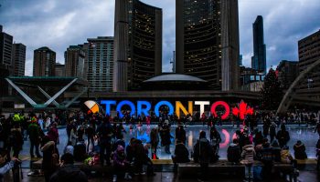 Vibrant evening at Toronto City Hall with festive crowd enjoying the cityscape.