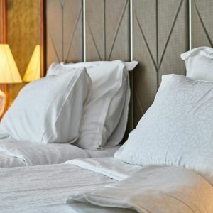 Inviting hotel room with comfortable bedding and ambient lighting, perfect for relaxation and luxury stay.