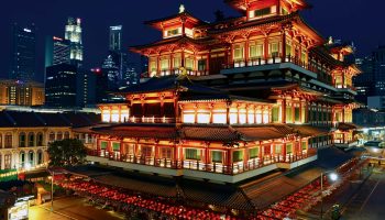 Night view of the beautifully lit Buddha Tooth Relic Temple in Singapore's Chinatown.